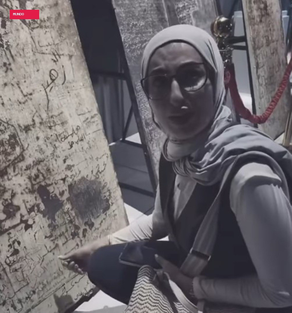 Mulher chora ao reconhecer nome de irmão desaparecido em porta de prisão em mostra sobre regime de Assad